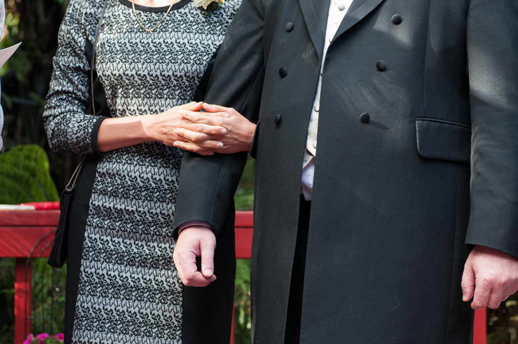 Maid of honour holds groom's arm Homosexual Home garden Wedding Auckland Photographer Anais Chaine