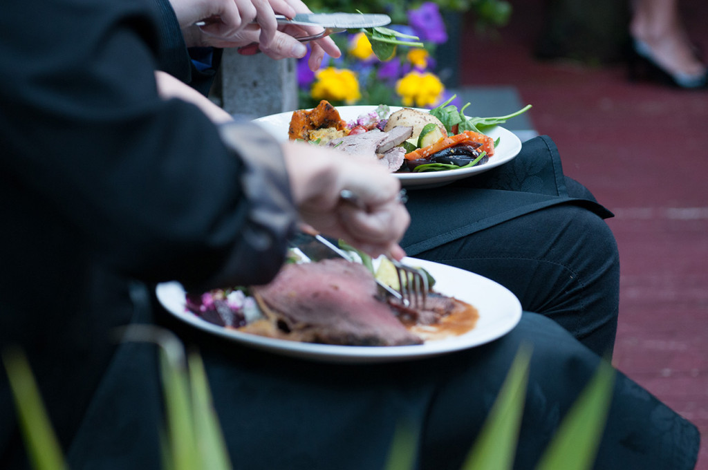 Guests cutting into the beautiful wedding roast Homosexual Home garden Wedding Auckland Photographer Anais Chaine