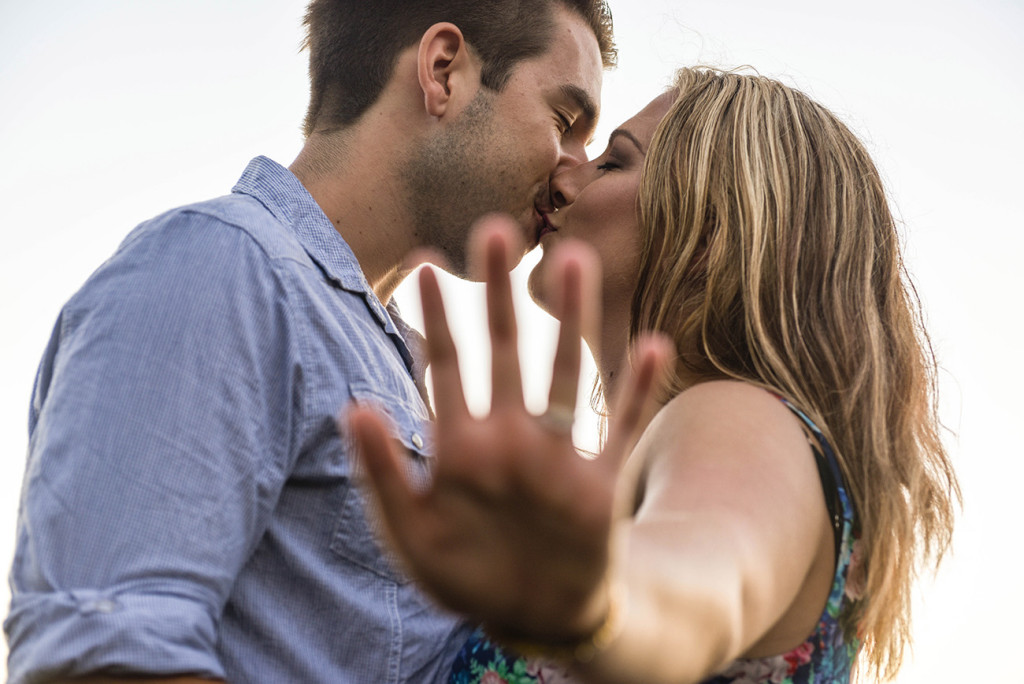 Blurred hand with ring and couple kissing