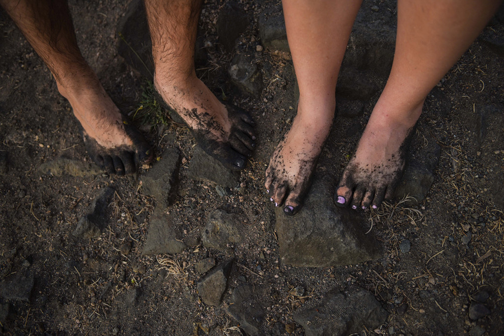 Feet in black sand engagement photo shoot couple