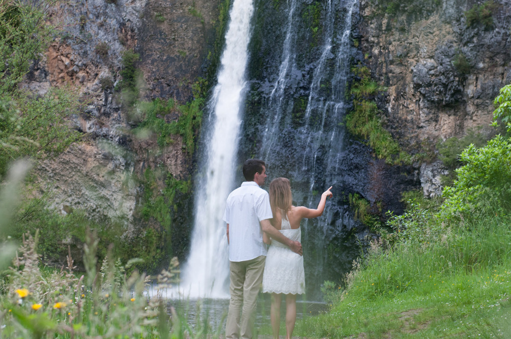 Lovers observing the beauty of the falls and the nature around she pointing out something far away