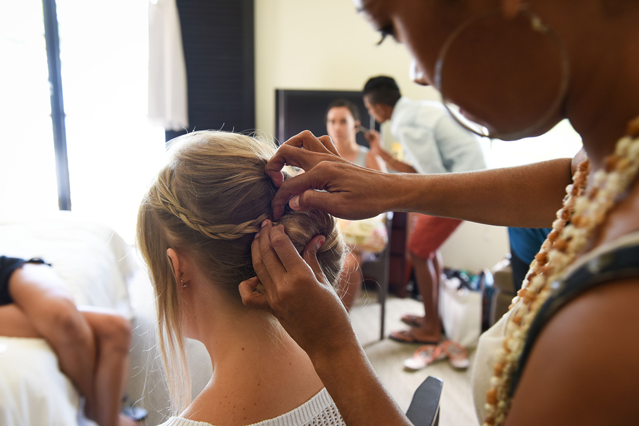 The hairdresser styling bridesmaid's hair in a beautiful bun