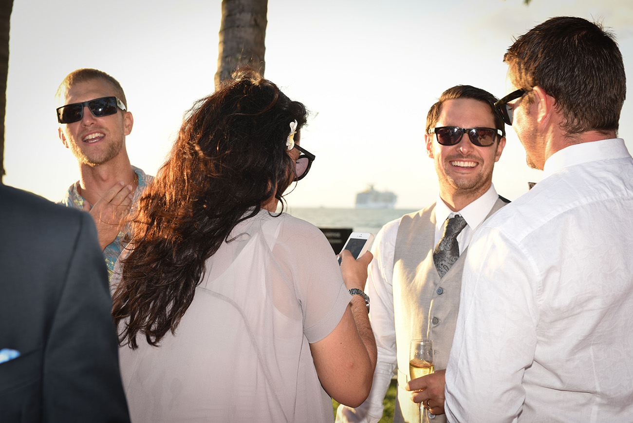 The groom laughing with his guests with a glass of champagne