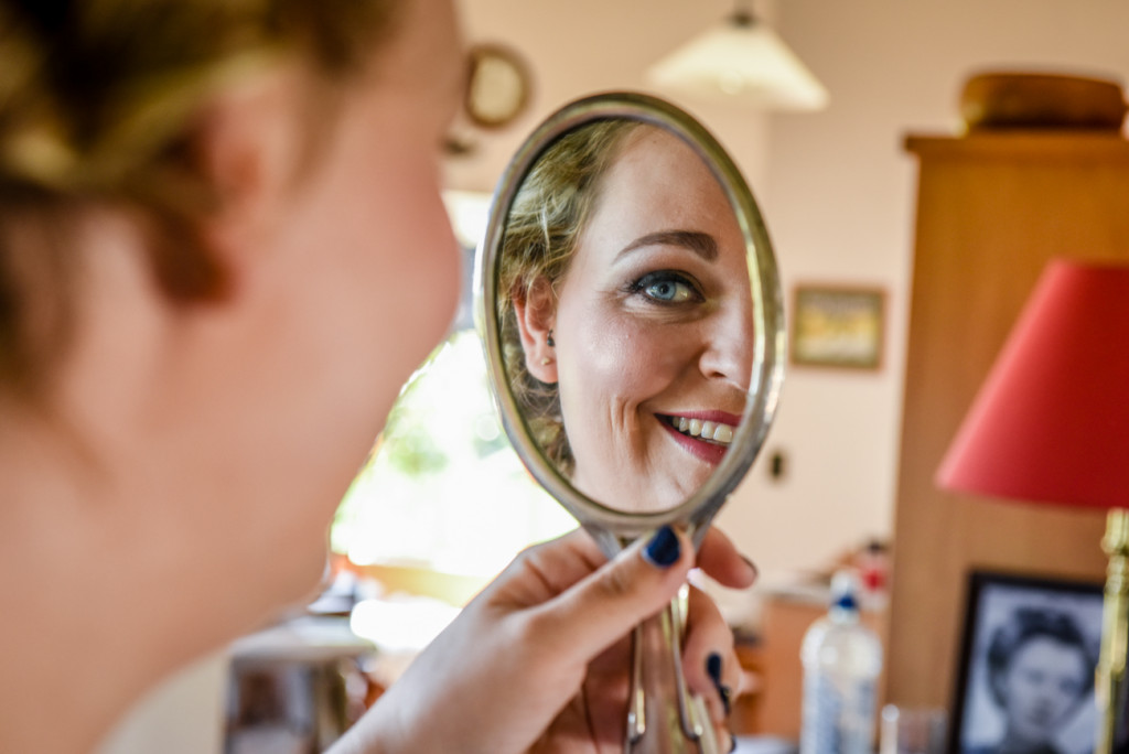 The bride checking her makeup in the mirror