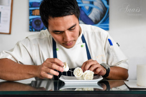 One of Taste of Fiji employee making icing roses for the decoration of a wedding cake. © Anais Photography.