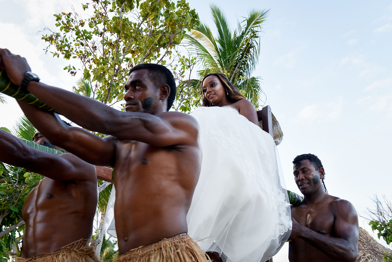 The Fijian warriors are carrying the bride to the wedding ceremony At Paradise Cove Island resort in the Yasawas, Fiji