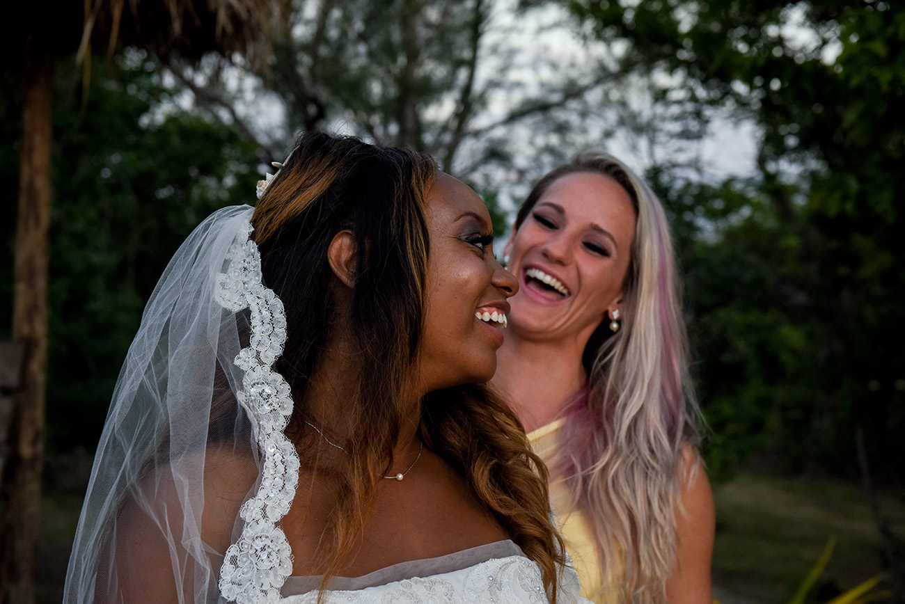 The bride and her bridesmaid are laughing together at Paradise Cove island resort in the Yasawas in Fiji photographed by Anais Photography