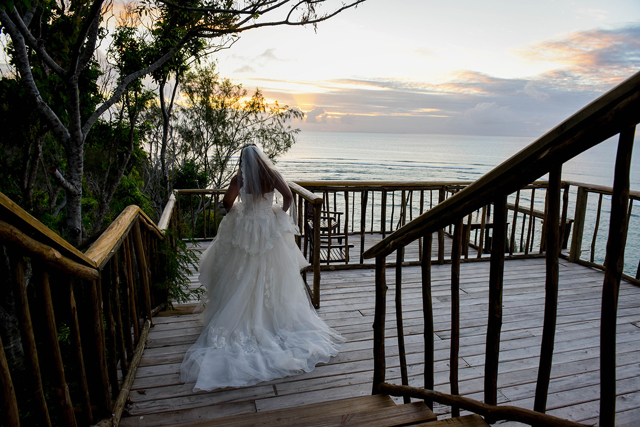 The bride is walking down the stairs at sunset point at Paradise Cove island resort in the Yasawas in Fiji photographed by Anais Photography