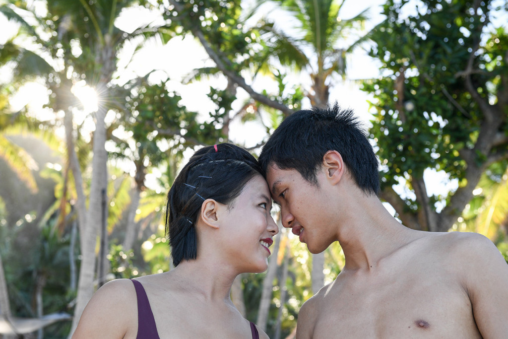 front head to front head couple staring at eachothers with palm trees in the background at Tokoriki island resort in Fiji photographed by Anais Photography