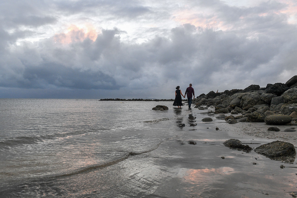 Couple walking along the rocks at Sandy in the sea at the Sheraton Resort in Denerau Island in Fiji