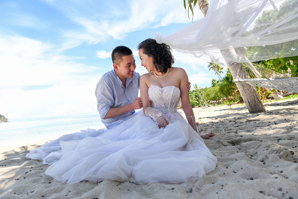 The groom is tickling his fiancee Paradise Cove island resort, Fiji