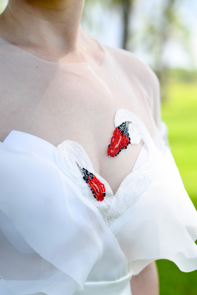 Detail of the bride's front of her wedding dress with swans