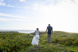 Bride and groom elope in green Fiji landscape walking into the Sunset