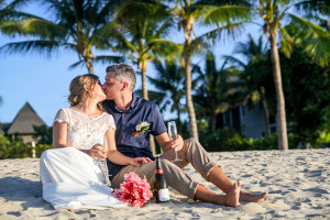 Eloped couple kiss on the beach with champagne on Coral Coast Fiji