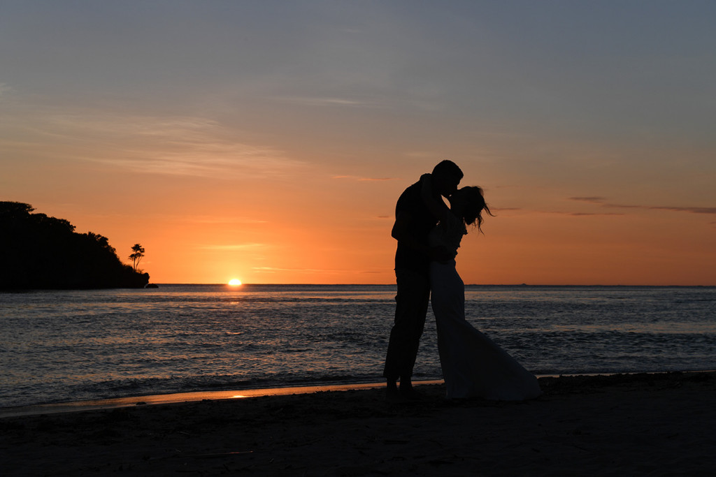 Silhouette kiss of eloped couple against Golden sunset on Coral Coast Fiji