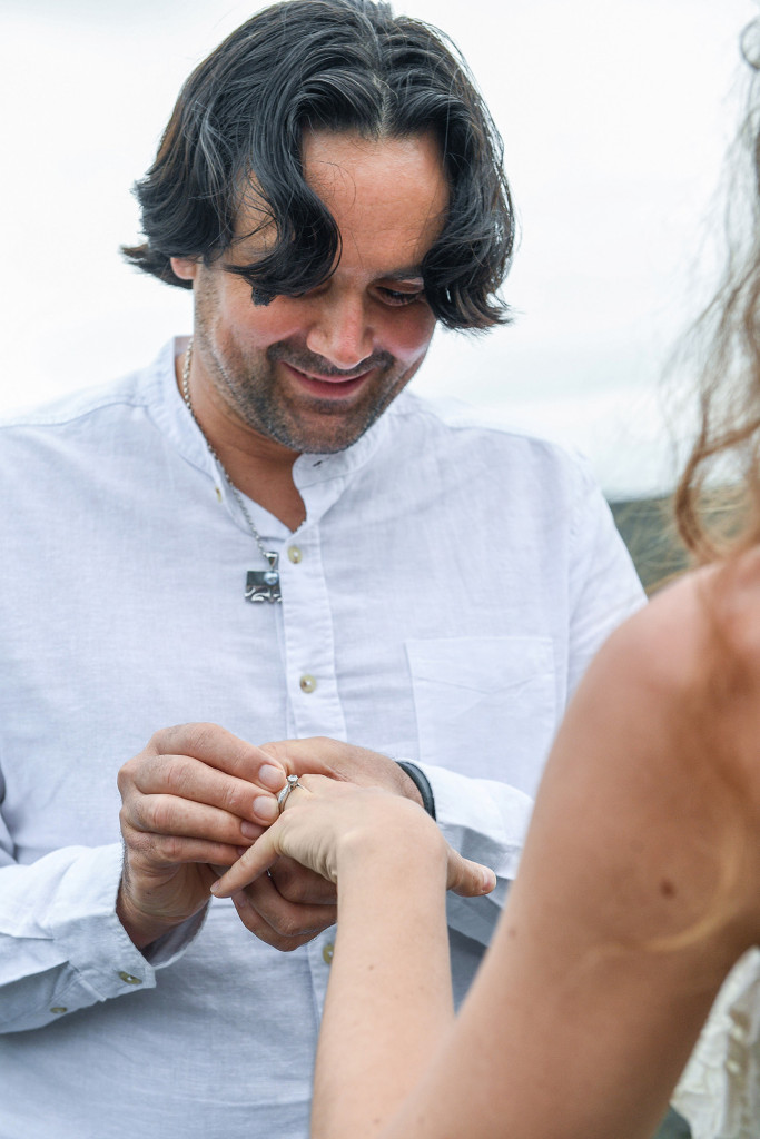 Bride wears ring on elopement wedding ceremony at Karekare Beach Auckland New Zealand