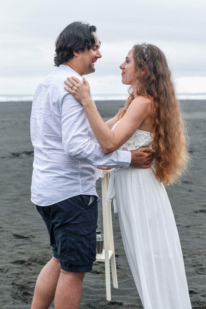 Bride and groom on black sand Karekare Beach Auckland New Zealand