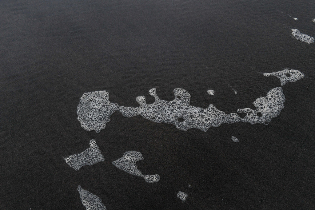 Sea form over the black sand beach Karekare Auckland NZ