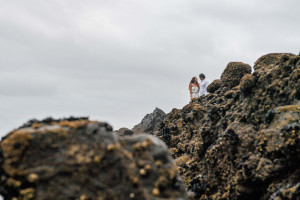 The couple seen in a distance at the black sand beaches of Karekare NZ