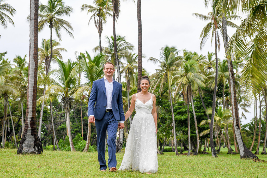 Couple walking past palm trees at Vomo Island Resort Fiji