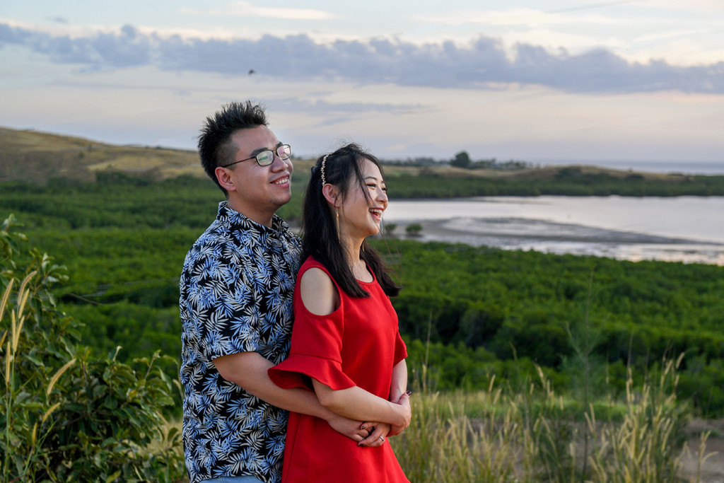 Loving couple stare into sunset at the coral coast of Denarau Island Fiji in country engagement photoshoot