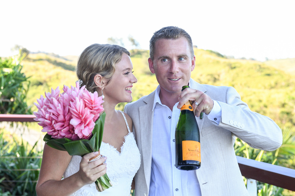 Groom drinks champagne off the bottle in Fiji wedding at the Outrigger Fiji