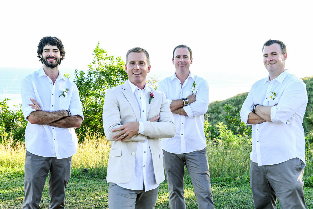 Groomsmen cross arms and pose in Fiji countryside