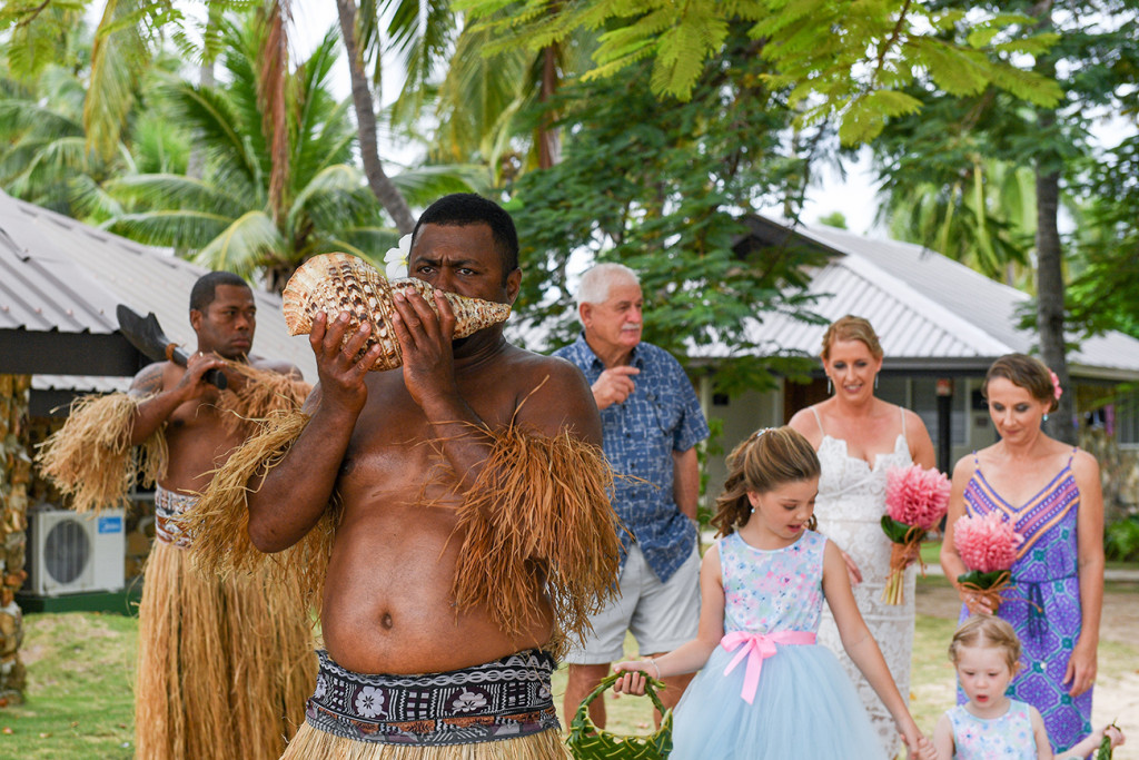 Traditional Fiji warrior blows ceremonious horn during Fiji wedding