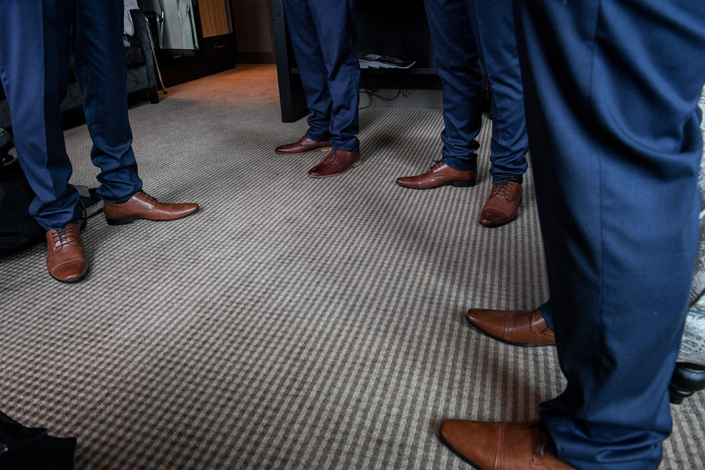 Closeup of groomsmen sleek brown leather shoes