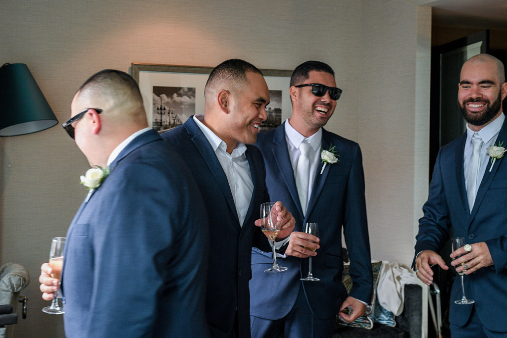 Groom & groomsmen laugh during wedding prep