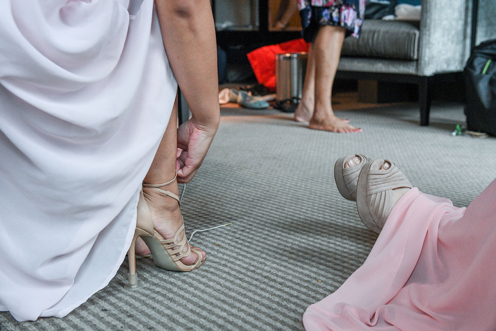 Bride adjusts shoes during wedding prep