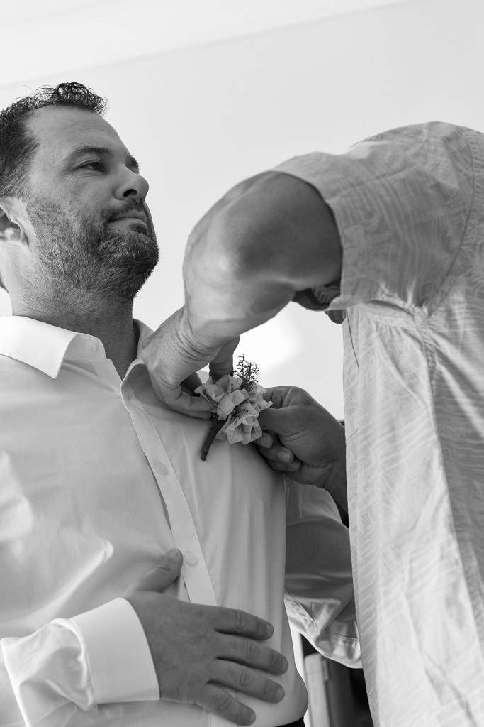 Black and white photo of groom getting ready