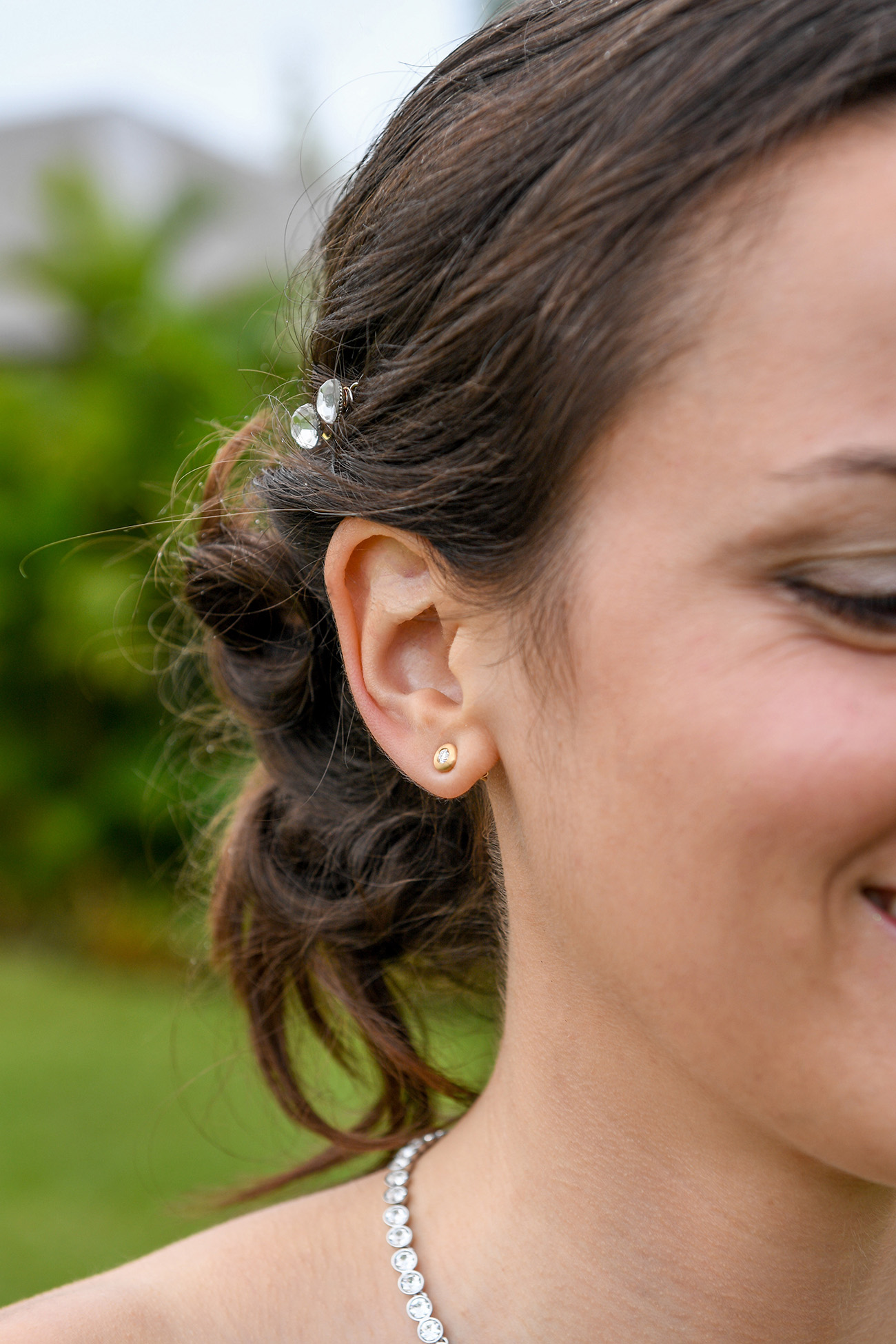 Closeup of bride's simple earrings and simple hair plait pinup