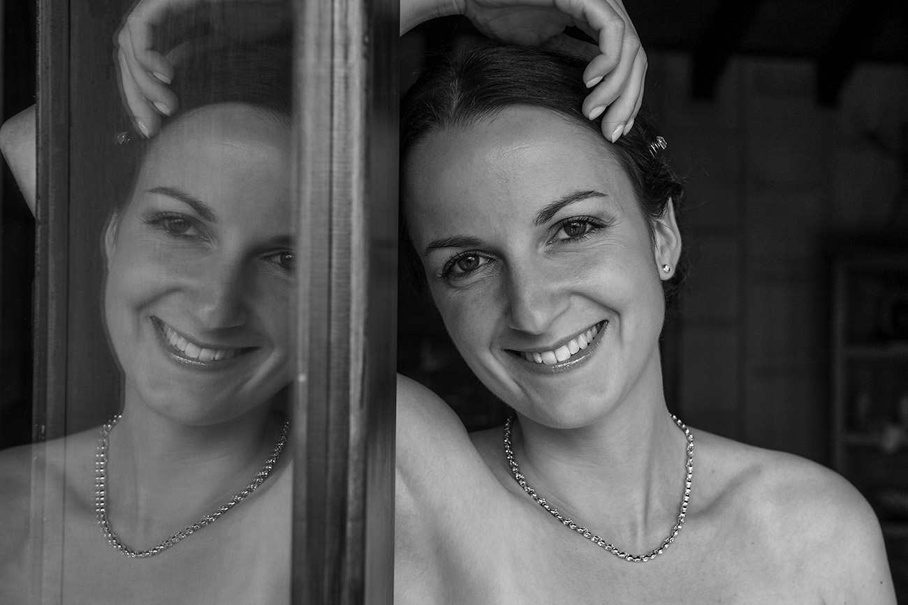 Black and white reflection of bride smiling