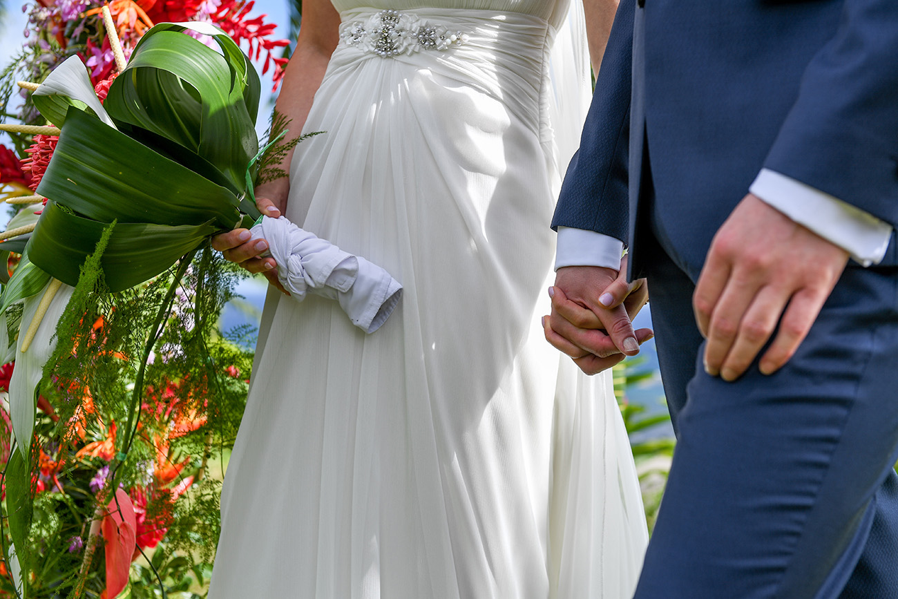 Closeup of Bride and groom holding hands at the altar