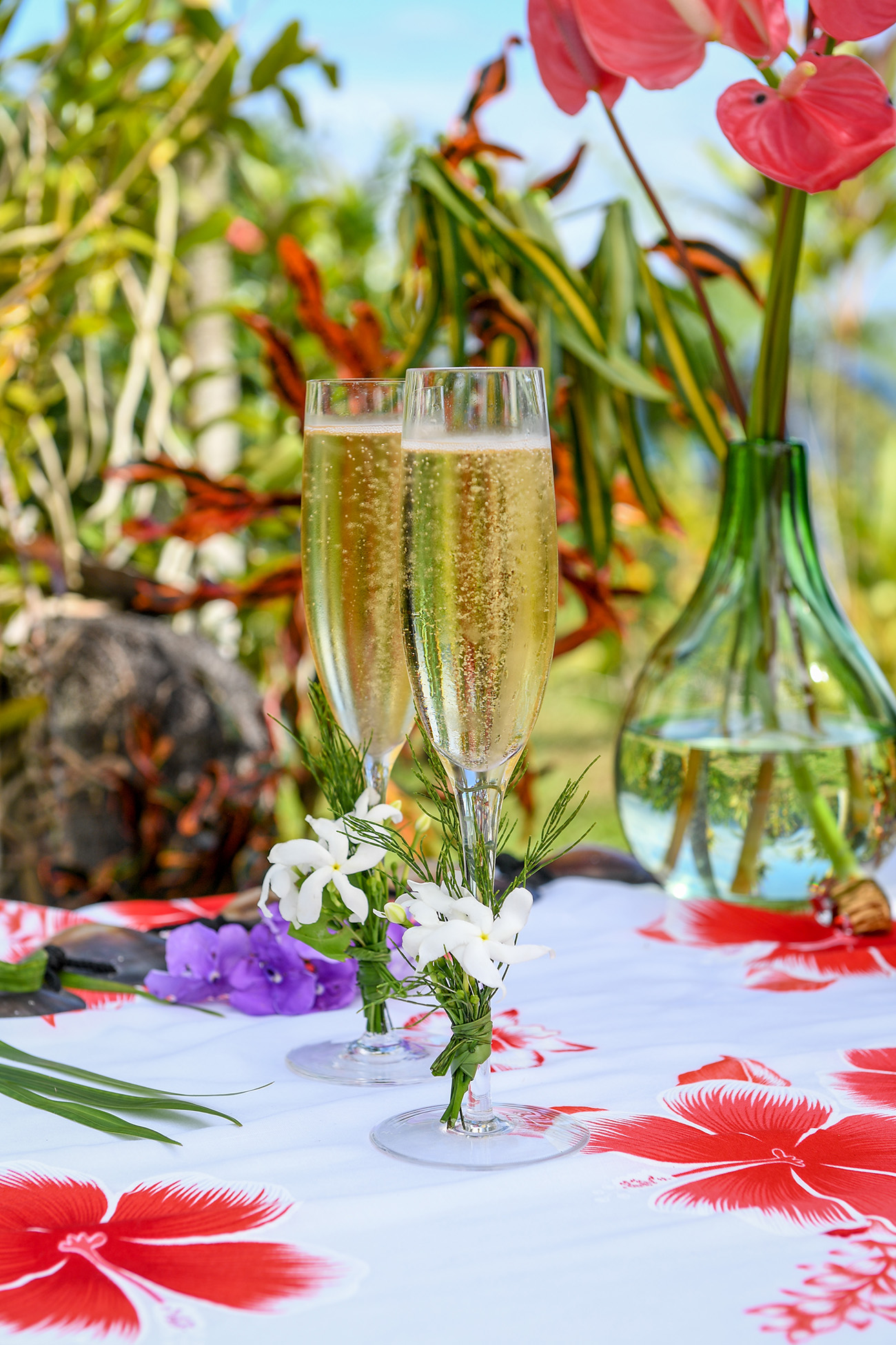 Two flutes of champagne decorated with native Fiji flowers in Savusavu Island Fiji wedding.