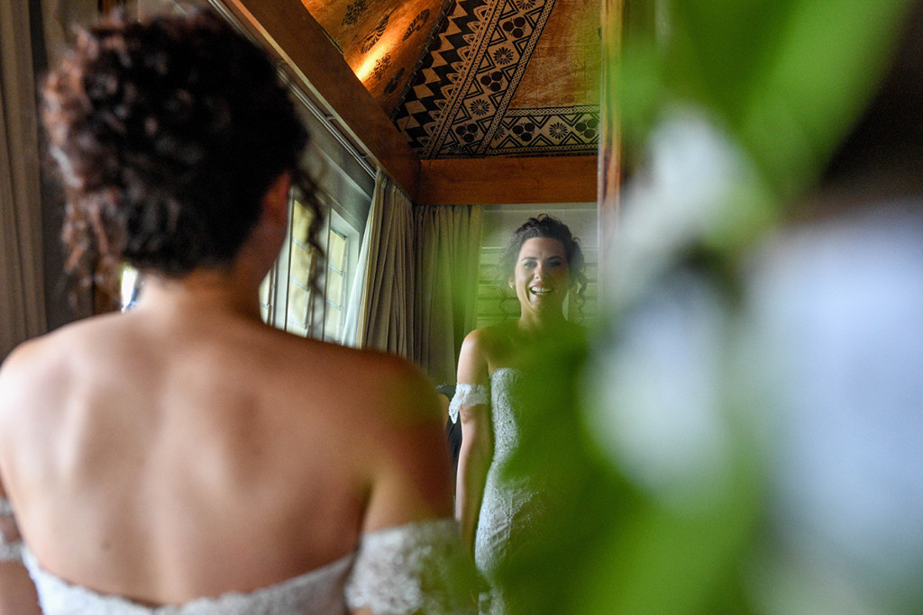 Stunning bohemian bride looking at her reflection before wedding