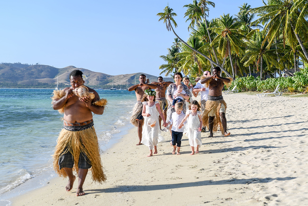 Bride being walked down the aisle by Fiji singers and horns