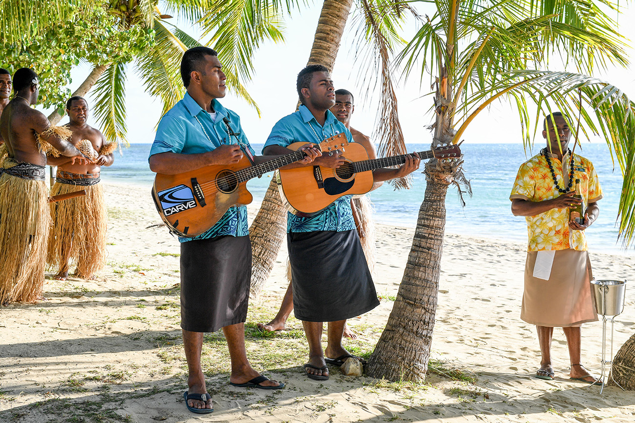 Traditional Fiji singers perform on the guitar for the newly married
