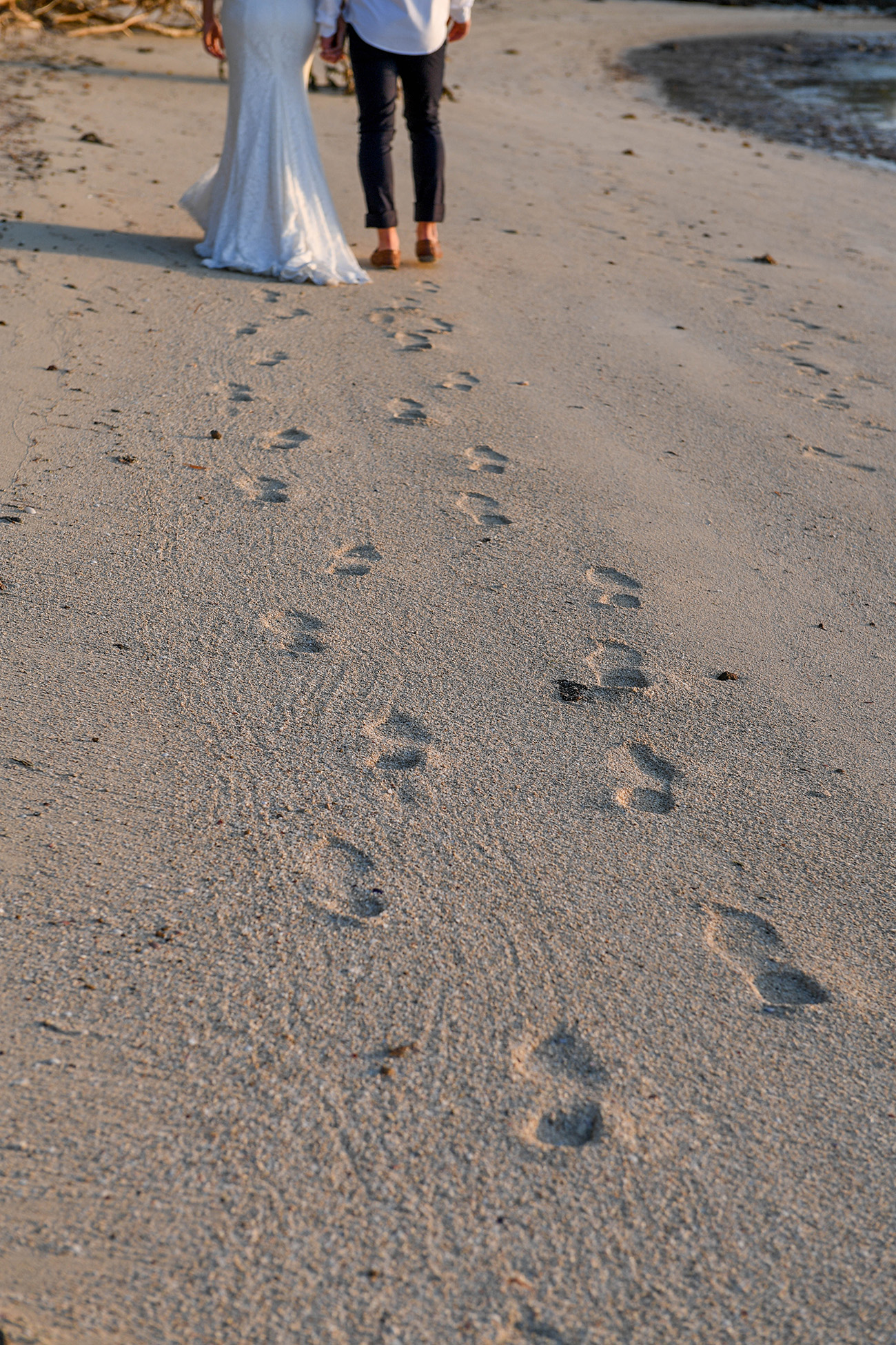 Footprints in the sand left behind by the bride and groom