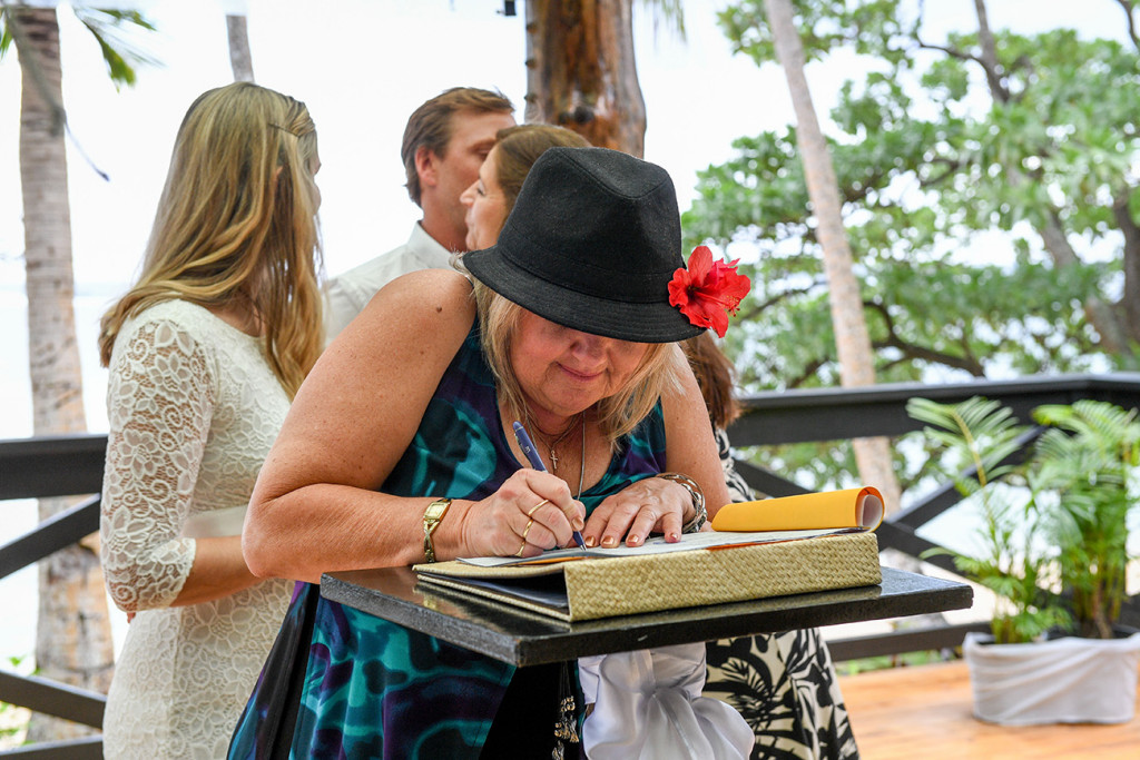 The mother is signing the register for her wedding in Fiji