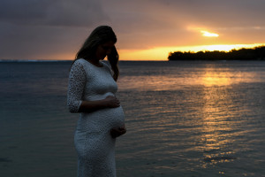 Silhouette of pregnant woman by the beach in Fiji at the Warwick