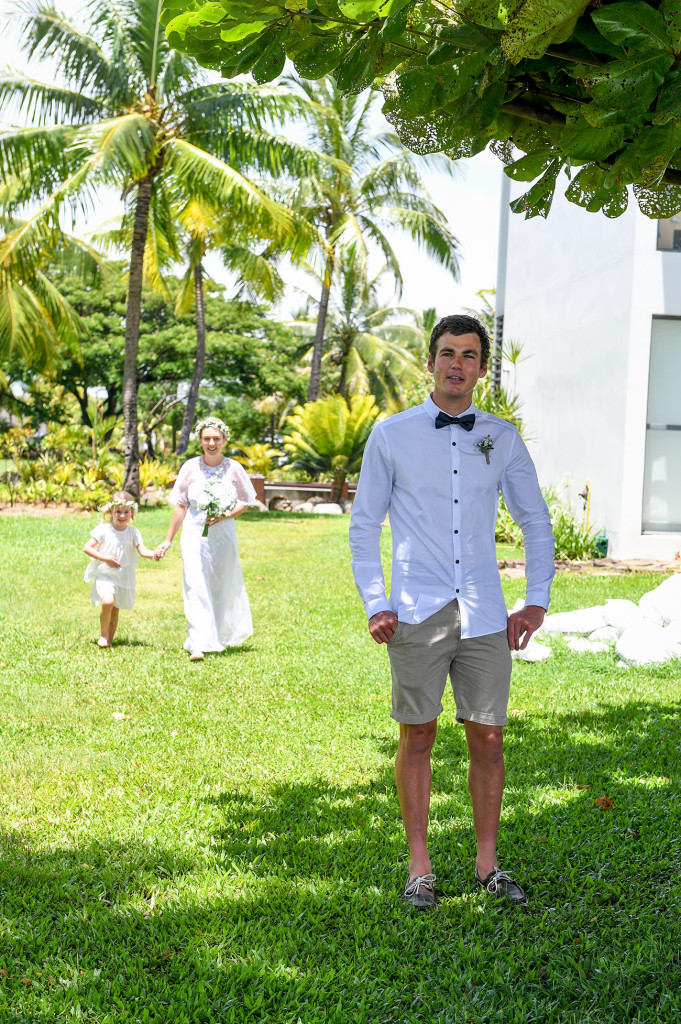 Bride and flowergirl walk up behind the unaware groom in Hilton Denarau Fiji