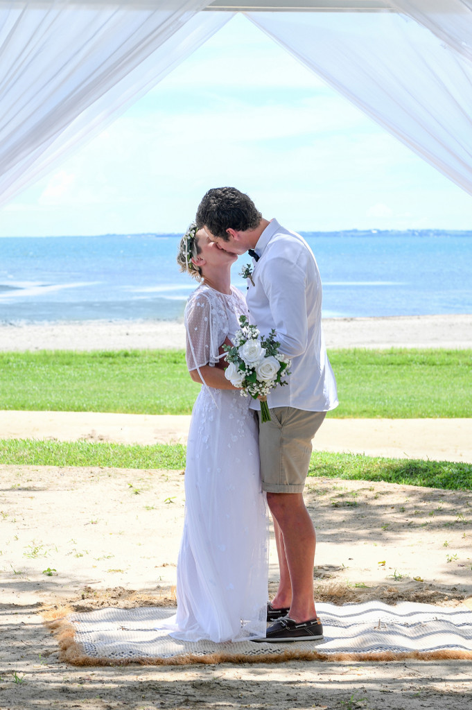 Bride and groom kiss against magnificent Pacific Ocean in Denarau Fiji