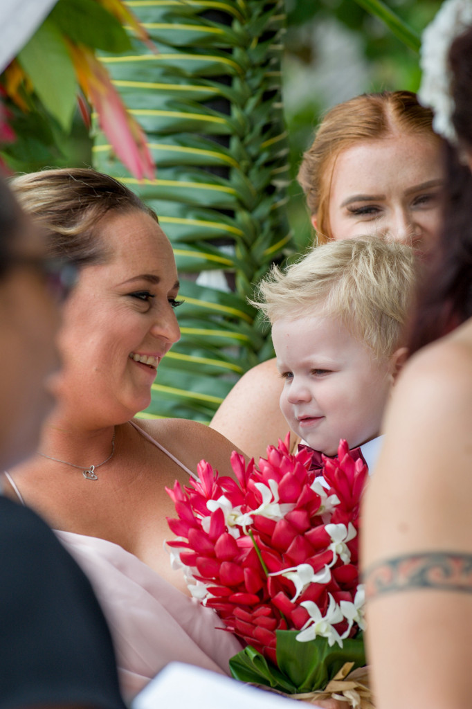 A bridesmaid smiles with the couple's son