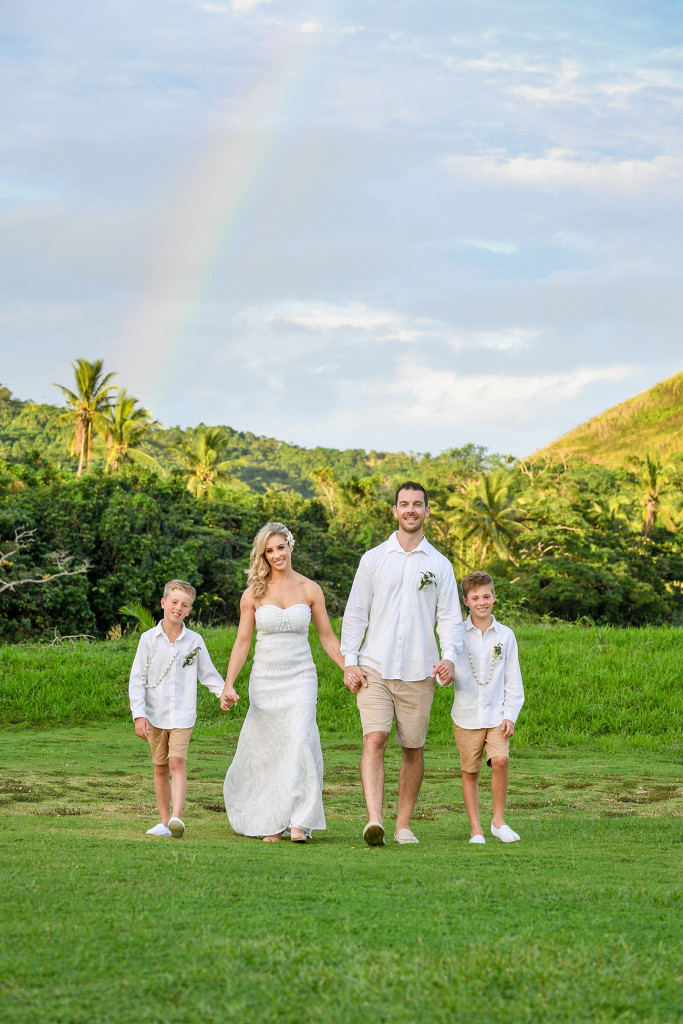 The happily married family in all white pose in the Fiji greenery