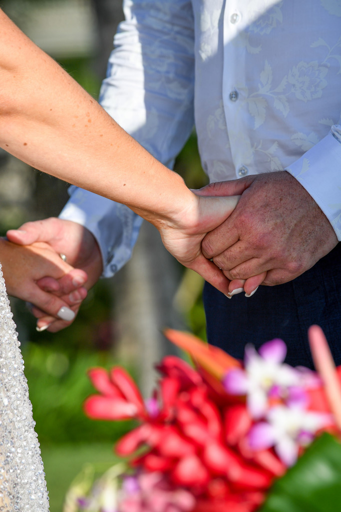 Closeup of the happy couple holding hands at the altar