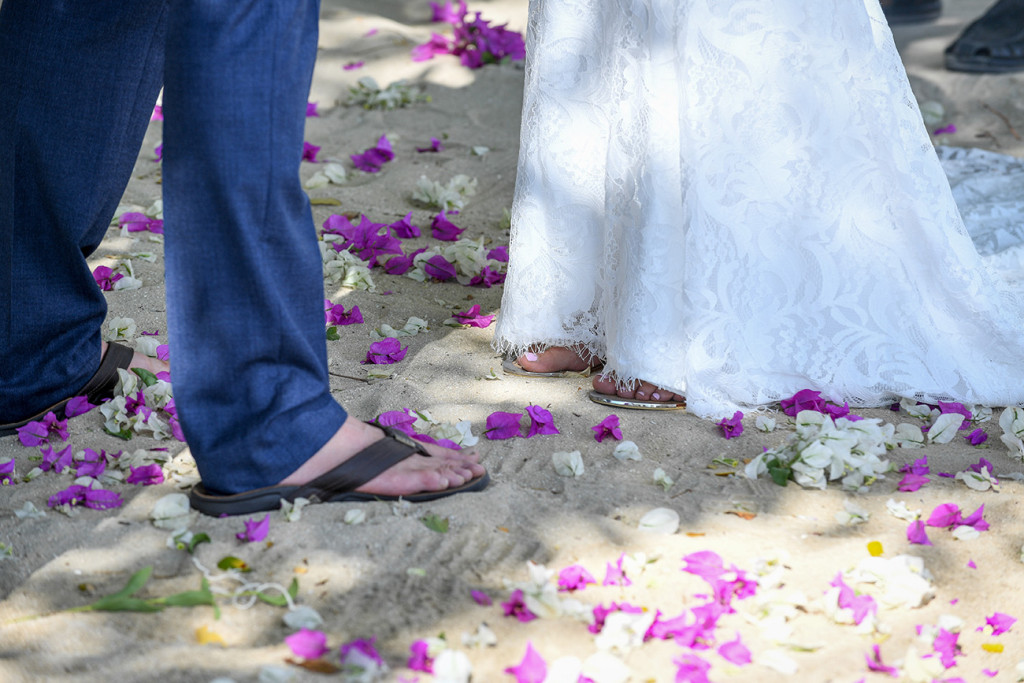 Violet flower petals strewn at the altar at the feet of the bride and groom at the shores Musket Cove Fiji
