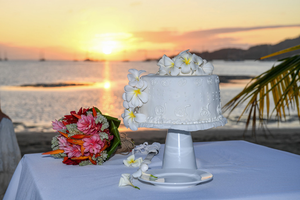 Brilliant white tropical Fiji wedding cake photographed at Sunset