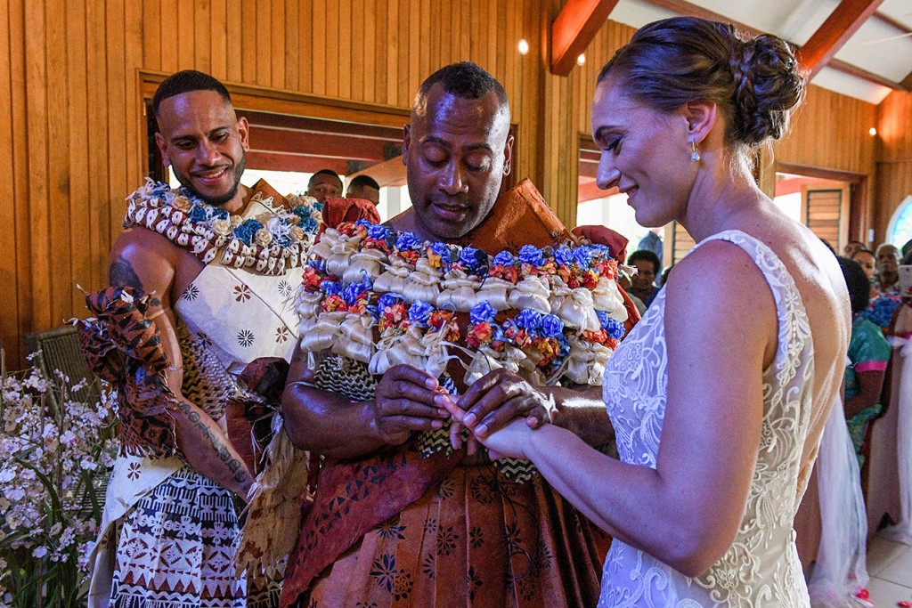 The groom says his vows as he slips the wedding band onto his bride